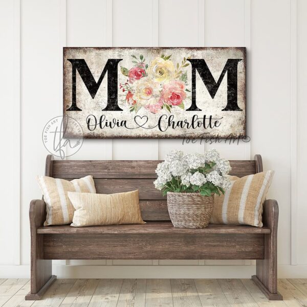Toe Fish Art's unique, artisan-made Vintage Flower Bouquet "MOM" sign personalized with hand-lettered cursive family names to fit your style. This custom wall art is available as a wood-framed canvas with choice of framing colors, or outdoor waterproof metal, showcasing a worn rustic white background with bold black lettering and a beautiful painting of red, pink, and yellow roses. An ideal Mother's Day gift or any special occasion to celebrate Mom! Expertly made with American-sourced materials. This premium, handcrafted piece features a timeless aesthetic. Built to last with genuine craftsmanship, it adds rustic charm and heritage quality to any space. Made in the USA with durable, authentic materials for a beautiful and meaningful display. Rustic Cottagecore Country and Modern Farmhouse wall decor handcrafted in durable high-quality framed canvas or outdoor weatherproof solid aluminum metal, handmade in the USA from start to finish! Beautiful, stylish and timeless floral wall decor painting. Handcrafted in the USA by ToeFishArt, and built to last a lifetime by the Toe Fish Art family artisans. This beautiful original artwork adds unique eye-catching decor indoors or outdoors. Add instant outdoor curb appeal to your home! Perfect for your porch, entryway, patio, lanai, deck, garden, courtyard, gazebo, pergola, living room, fireplace hearth or mantel, wall hanging or shelf sitter, dining room or bedroom. This painting is a beautiful reminder of the gift of Mom's love to celebrate her for Mother's Day and all-year long. Original, custom, personalized wall decor signs. Canvas, Wood or Metal. Rustic modern farmhouse, cottagecore, vintage, retro, industrial, Americana, primitive, country, coastal, minimalist. Toe Fish Art is a USA small family woman owned business making beautiful decor since 1997.