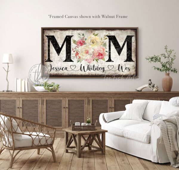 Toe Fish Art's unique, artisan-made Vintage Flower Bouquet "MOM" sign personalized with hand-lettered cursive family names to fit your style. This custom wall art is available as a wood-framed canvas with choice of framing colors, or outdoor waterproof metal, showcasing a worn rustic white background with bold black lettering and a beautiful painting of red, pink, and yellow roses. An ideal Mother's Day gift or any special occasion to celebrate Mom! Expertly made with American-sourced materials. This premium, handcrafted piece features a timeless aesthetic. Built to last with genuine craftsmanship, it adds rustic charm and heritage quality to any space. Made in the USA with durable, authentic materials for a beautiful and meaningful display. Rustic Cottagecore Country and Modern Farmhouse wall decor handcrafted in durable high-quality framed canvas or outdoor weatherproof solid aluminum metal, handmade in the USA from start to finish! Beautiful, stylish and timeless floral wall decor painting. Handcrafted in the USA by ToeFishArt, and built to last a lifetime by the Toe Fish Art family artisans. This beautiful original artwork adds unique eye-catching decor indoors or outdoors. Add instant outdoor curb appeal to your home! Perfect for your porch, entryway, patio, lanai, deck, garden, courtyard, gazebo, pergola, living room, fireplace hearth or mantel, wall hanging or shelf sitter, dining room or bedroom. This painting is a beautiful reminder of the gift of Mom's love to celebrate her for Mother's Day and all-year long. Original, custom, personalized wall decor signs. Canvas, Wood or Metal. Rustic modern farmhouse, cottagecore, vintage, retro, industrial, Americana, primitive, country, coastal, minimalist. Toe Fish Art is a USA small family woman owned business making beautiful decor since 1997.
